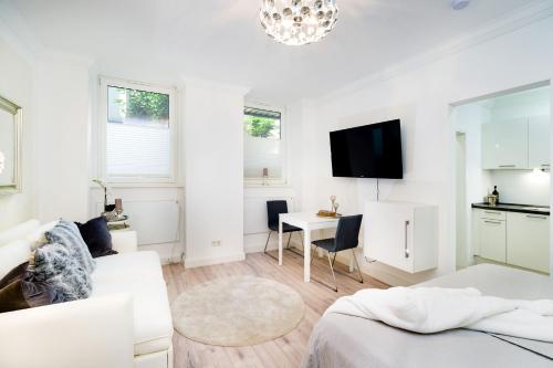 a white living room with a white couch and a table at Budget Studio Kreuzberg - Lachmannstr 3 HH in Berlin