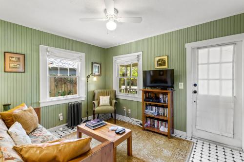 a living room with a couch and a tv at Charming 1923 Cottage at Erehwon Retreat in Tampa