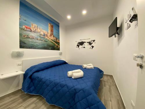 um quarto com uma cama azul com toalhas em IN CENTRO ROOMS Vicino Cefalù SELF-CHEK-IN em Campofelice di Roccella