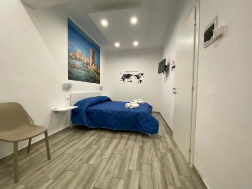 a bedroom with a blue bed and a chair at IN CENTRO ROOMS Vicino Cefalù SELF-CHEK-IN in Campofelice di Roccella