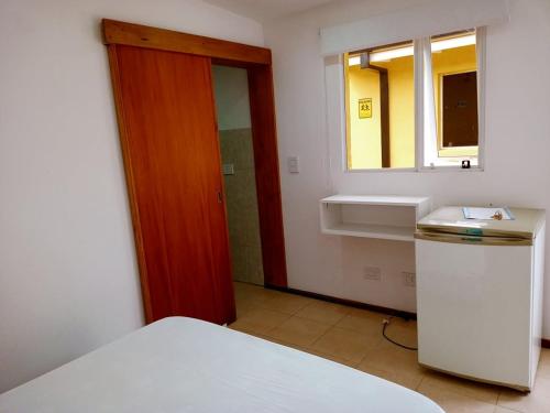 een kamer met een bed, een deur en een raam bij Hotel Atlantis in San Bernardo