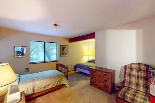 a bedroom with two beds and a chair at Forest Glen in Yosemite West