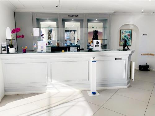 a store with a white counter in a room at Hôtel D'orsay in Orsay