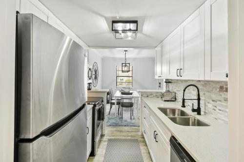 a kitchen with white cabinets and a stainless steel refrigerator at #49 Cheerful 2 BDR with Pool & Assigned 2 Parking in Hilton Head Island