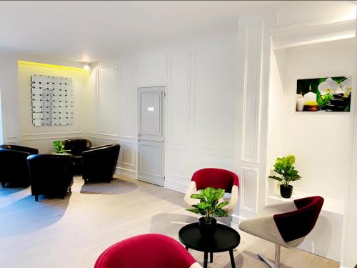 a waiting room with red chairs and a table at Hôtel D'orsay in Orsay