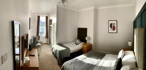 a hotel room with two beds and a television at Membly Hall Hotel in Falmouth