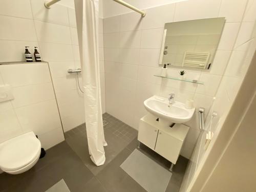 Baño blanco con aseo y lavamanos en Apartment - 3 Einzelbetten - Stellplatz - Netflix en Goch