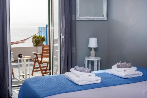 - une chambre avec un lit, des serviettes et un balcon dans l'établissement Agistri By The Sea, à Perama