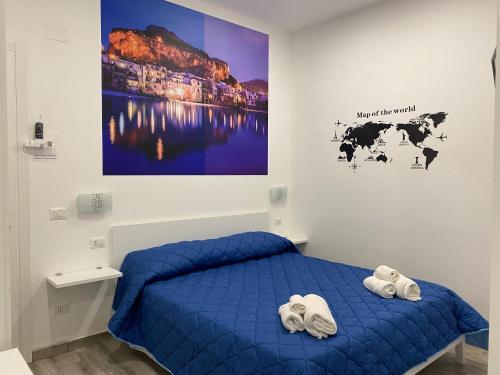 a bedroom with a blue bed with towels on it at IN CENTRO ROOMS Vicino Cefalù SELF-CHEK-IN in Campofelice di Roccella