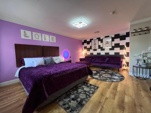 a purple bedroom with a bed and a couch at Orbits Inn in Somerset