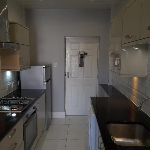 uma cozinha com um fogão e uma porta branca em Lytham Apartment em Lytham St Annes