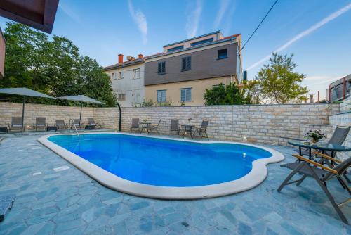 einen Pool in einem Hof mit einem Gebäude in der Unterkunft Apartments Žuvela in Split