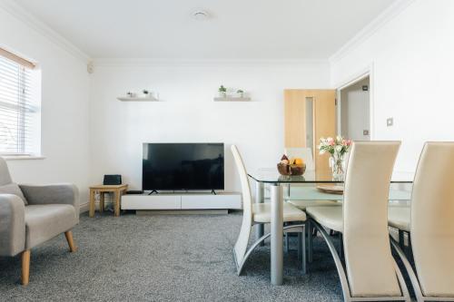 a living room with a dining table and a tv at Spacious 2 bedroom flat near beach and town centre in Bournemouth