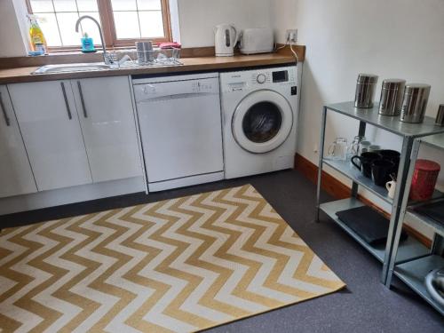 a kitchen with a washing machine and a sink at Balnakiel Cottage, Galashiels in Torwoodlee