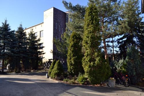 un edificio con árboles frente a una calle en Kujawianka en Ciechocinek