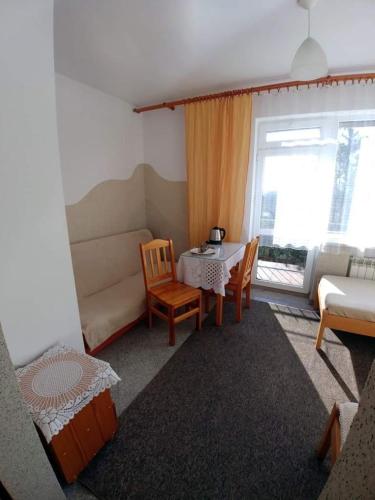 sala de estar con mesa y sofá en Kujawianka en Ciechocinek