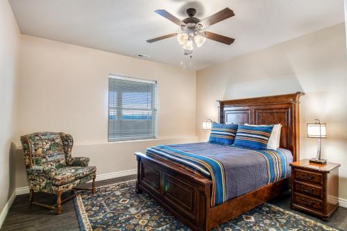 1 dormitorio con 1 cama con ventilador de techo y silla en Kerry Hill Manor, en Wilder