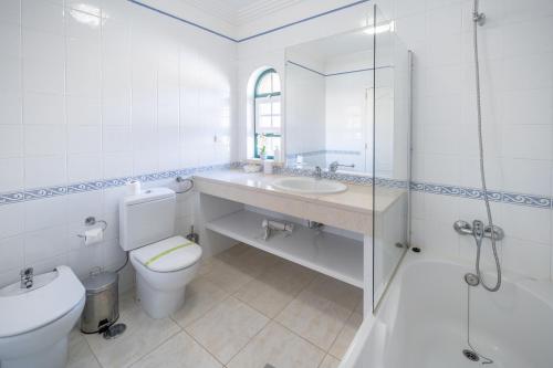 a bathroom with a toilet and a sink and a shower at Villa Balaia by HelloVacations in Albufeira