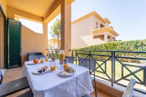a table with food and orange juice on a balcony at Villa Balaia by HelloVacations in Albufeira