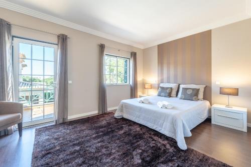 a bedroom with a bed and a large window at Villa Balaia by HelloVacations in Albufeira