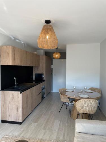 une cuisine avec une table et une salle à manger dans l'établissement Le P'tit Carnon, à Mauguio