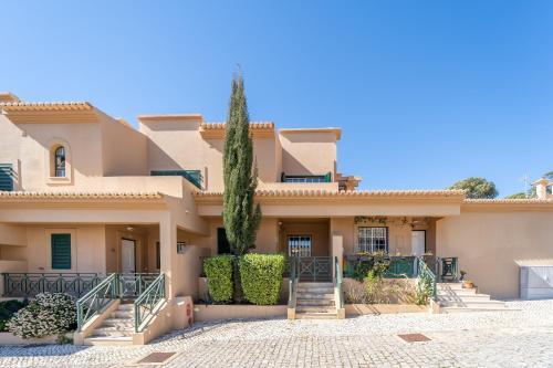 a villa with a palm tree in front of it at Villa Balaia by HelloVacations in Albufeira