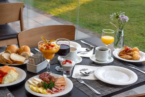 uma mesa coberta com pratos de alimentos e bebidas em Laghetto Stilo Vita em Gramado