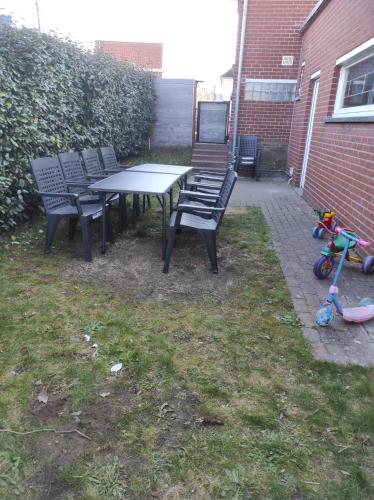 a picnic table and chairs in a yard with a childs stroller at 't Calmeyntje in De Panne