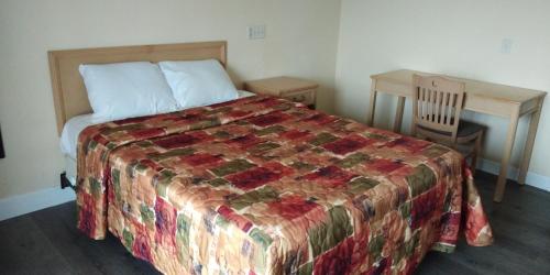a bedroom with a bed with a quilt and a desk at Spring Valley Inn in Spring Valley