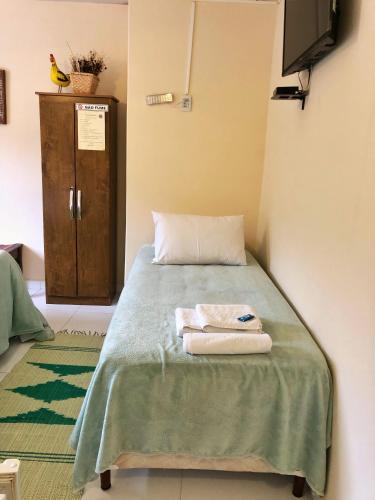 a bedroom with a bed with two towels on it at Estalagem e Restaurante Cantinho Bistrô in Alto Caparao