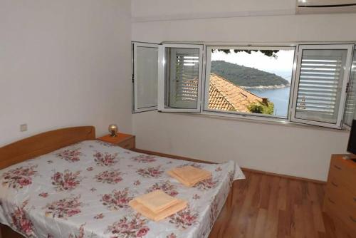una camera con un letto e una grande finestra di Studio Apartment Bupić- Close to Old City with Free Parking a Dubrovnik