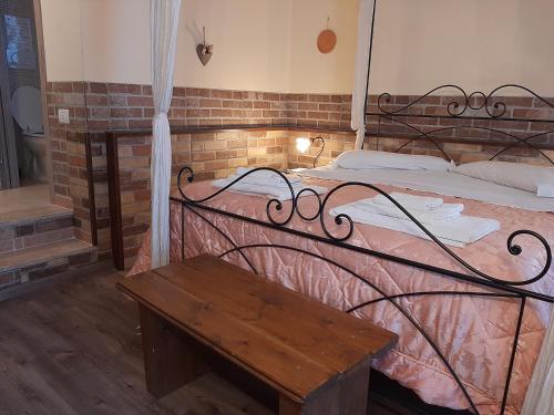 ein Bett mit einer Holzbank in einem Zimmer in der Unterkunft Il Girasole B&B in Cretone