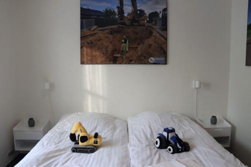 two toy cars sitting on top of a bed at Roslev Hus in Roslev