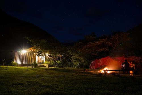a group of people sitting around a tent at night at Vertikal lodge in Santa Teresa