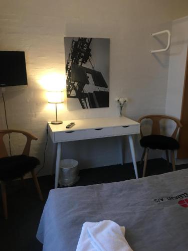 a desk in a room with a bed and a lamp at Roslev Hus in Roslev
