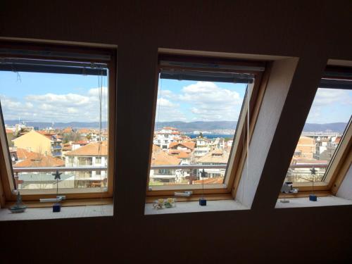 3 ventanas en una habitación con vistas a la ciudad en Nesebar Vigo Panorama Apartments en Nesebar