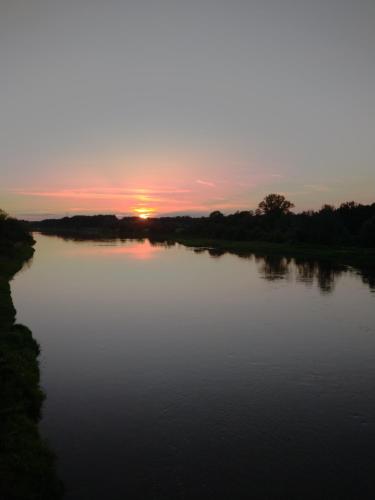 a view of a river with the sunset in the background at W Łęgu Natury in Nur