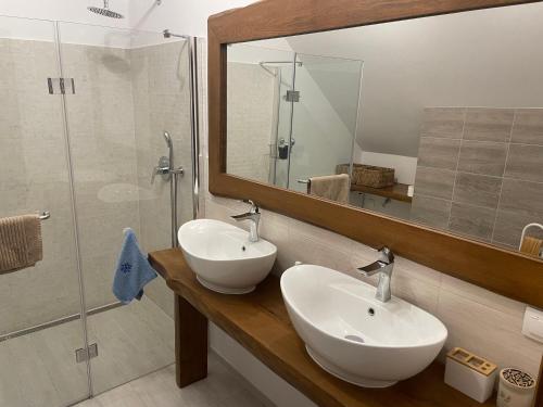 a bathroom with two sinks and a shower with a mirror at W Łęgu Natury in Nur