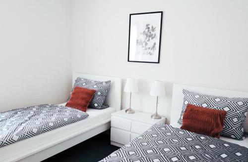 een slaapkamer met 2 bedden en rode kussens bij Apartment24 in Lügde