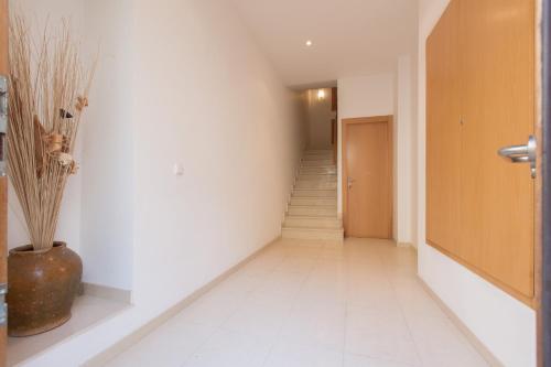 un pasillo con escaleras y un jarrón en el suelo en Apt Costa Dorada 1 by MarCalma, en Creixell