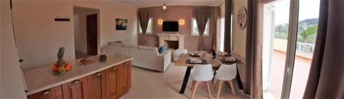 Villa Melody Complex في Akrotiri: غرفة معيشة مع طاولة وكراسي في غرفة