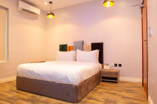 a bedroom with a large bed with white sheets at Riivana Tavern in Lekki