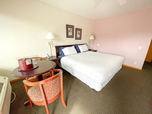 a hotel room with a bed and a table at Lake Bluff Inn and Suites in South Haven