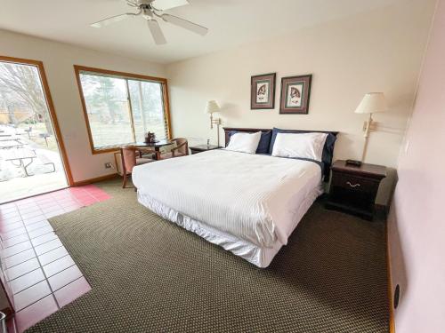 a bedroom with a large white bed and a window at Lake Bluff Inn and Suites in South Haven