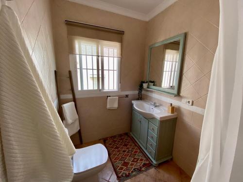y baño con lavabo, aseo y espejo. en Casa Lagom en Algodonales