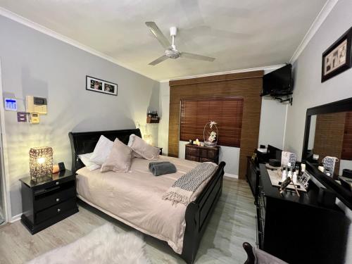 a bedroom with a bed and a ceiling fan at Welcome Estate Air B&B Hosting in Cape Town