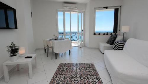 a living room with a white couch and a table at Due Relais - Panoramic Sea View Suites in Vietri sul Mare