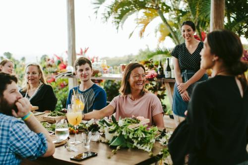 a group of people sitting around a table at The Lodge at Kukuiula - CoralTree Residence Collection in Koloa