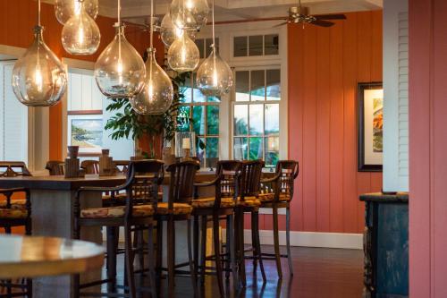 a restaurant with a bar with chairs and lights at The Lodge at Kukuiula - CoralTree Residence Collection in Koloa