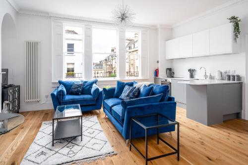 River Street View في باث: غرفة معيشة مع كرسيين ازرق ومطبخ